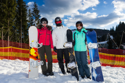 young people in ski suits helmet