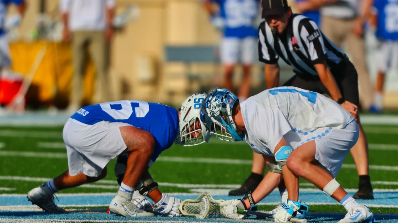 Lacrosse players in action on field.