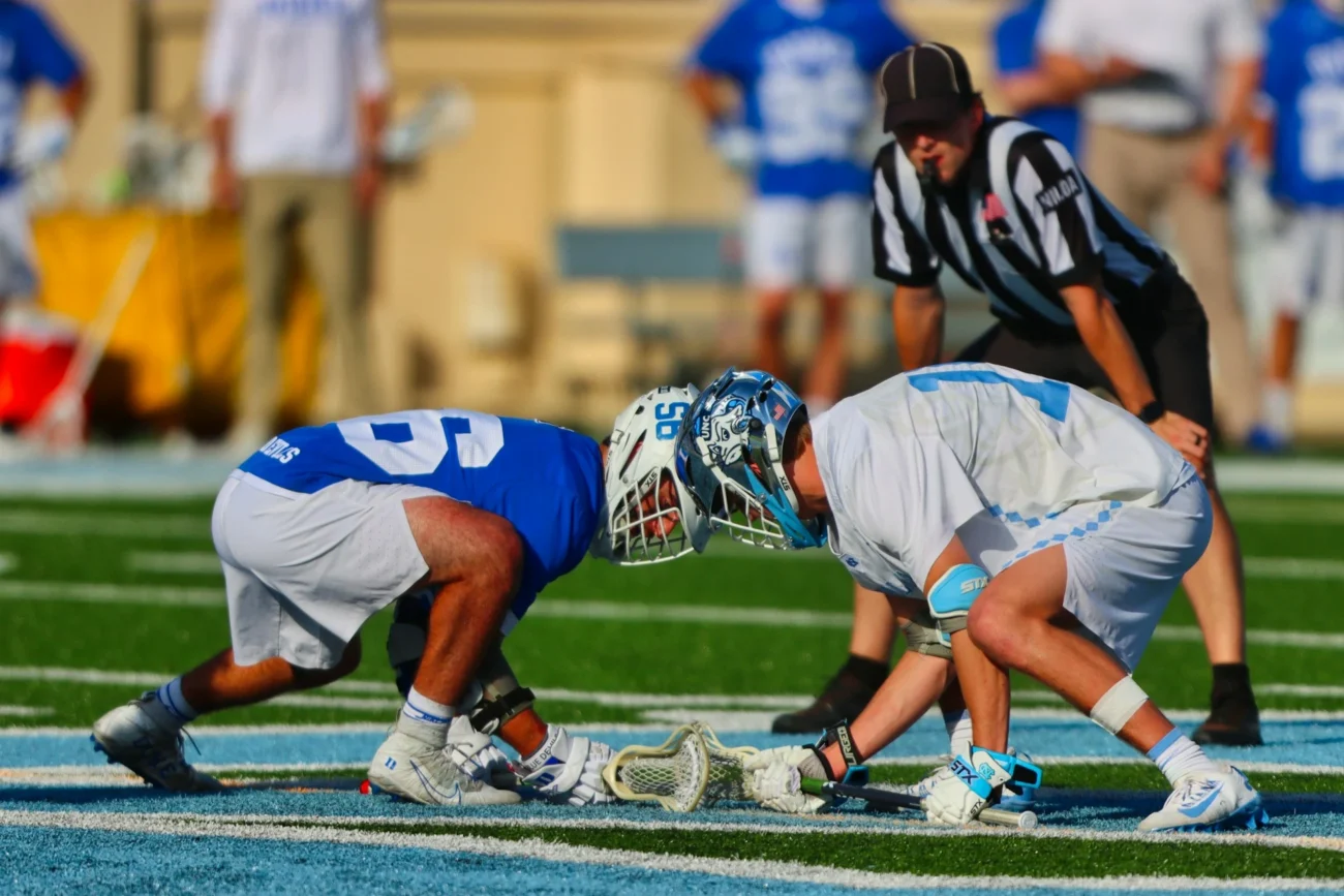 Lacrosse players in action on field.