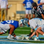Lacrosse players in action on field.