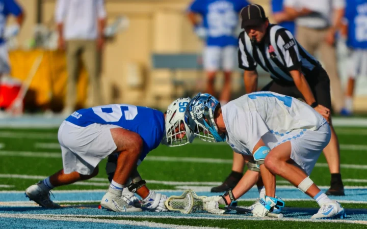 Lacrosse players in action on field.